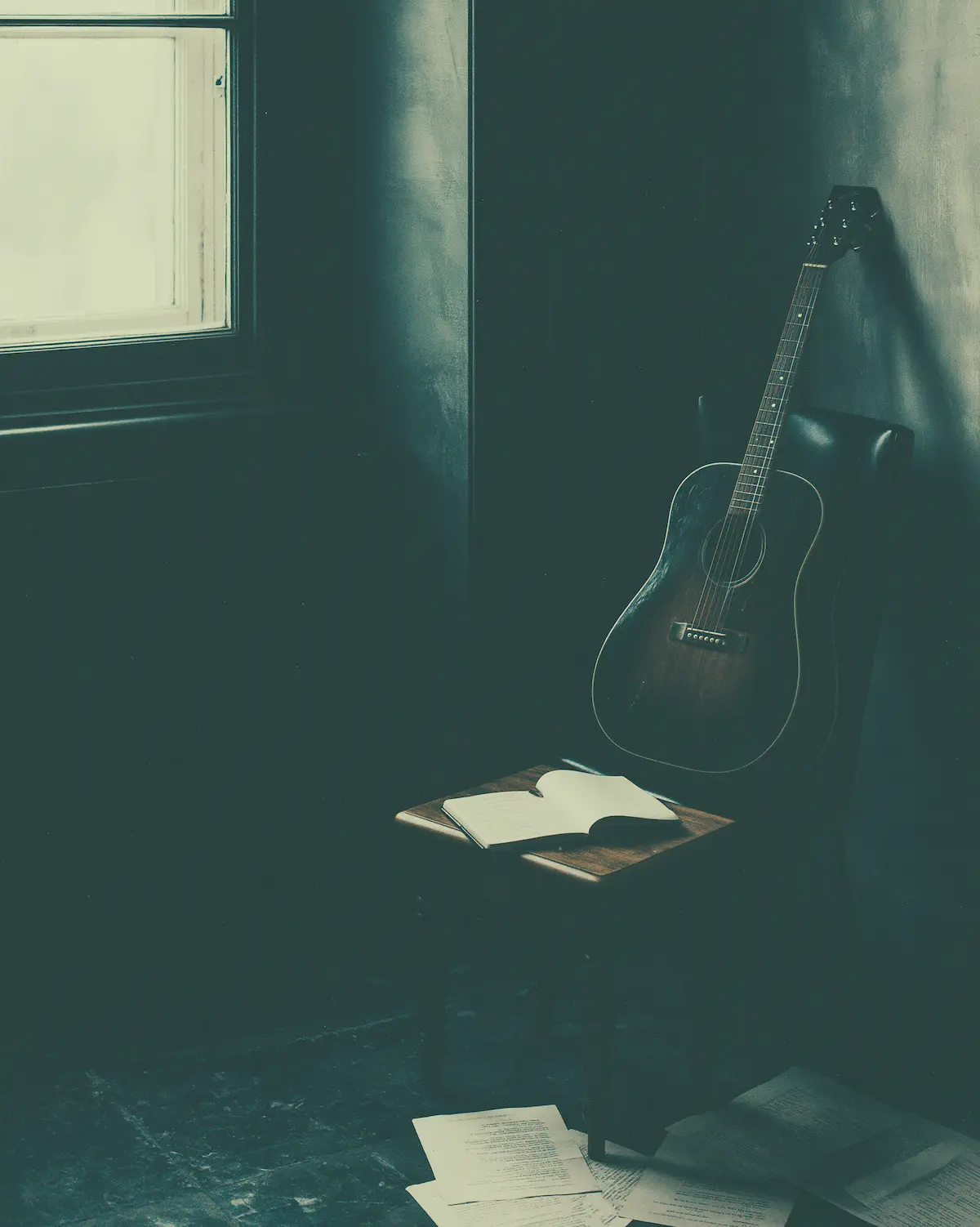 A quiet songwriting room with a guitar, notebook and soft window light